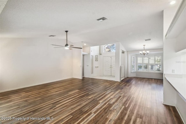 unfurnished living room with dark wood-type flooring, ceiling fan with notable chandelier, and a textured ceiling