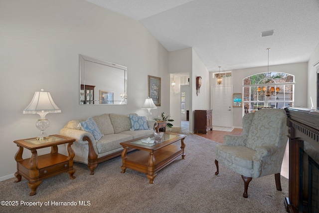 carpeted living room with lofted ceiling and a chandelier