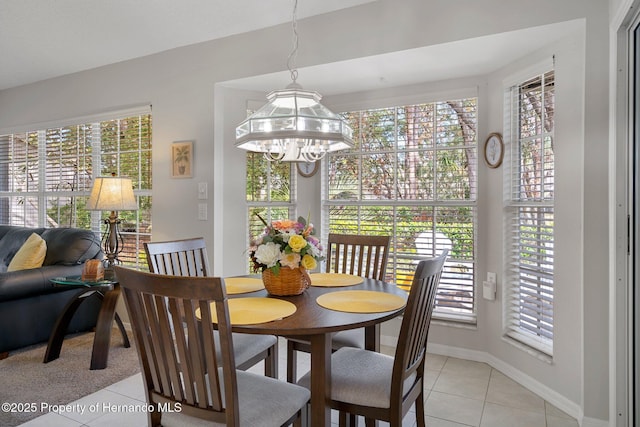 tiled dining room featuring a notable chandelier