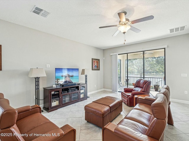 tiled living room with ceiling fan and a textured ceiling