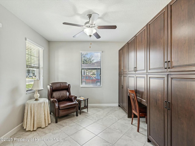 office space with light tile patterned floors, a textured ceiling, and ceiling fan