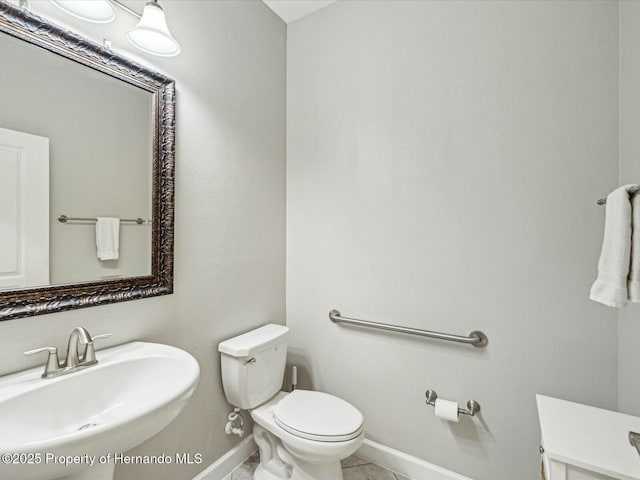 bathroom with tile patterned flooring, sink, and toilet