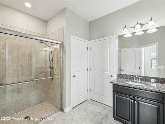 bathroom featuring a shower with door and vanity