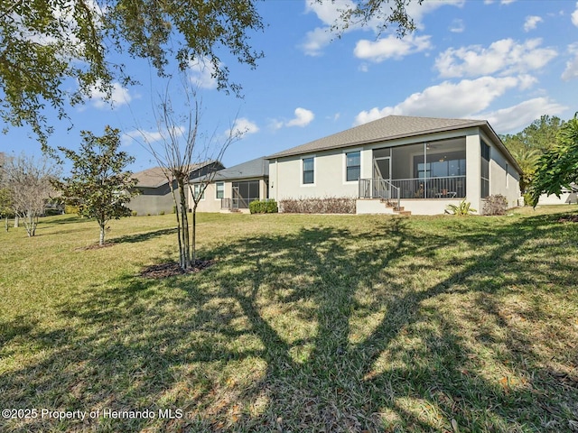 rear view of property with a yard and a sunroom