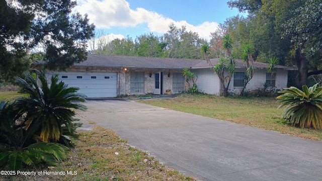 ranch-style home featuring a garage and a front lawn