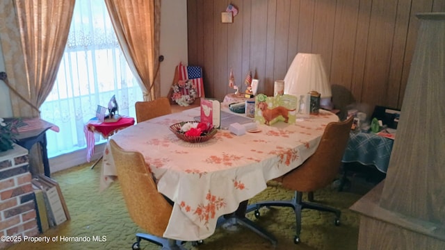 dining space featuring carpet and wood walls