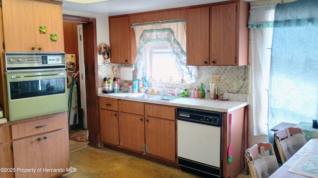 kitchen featuring tasteful backsplash, oven, sink, and dishwasher