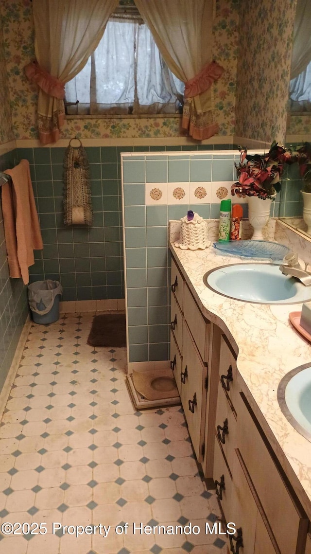 bathroom with vanity and tile walls