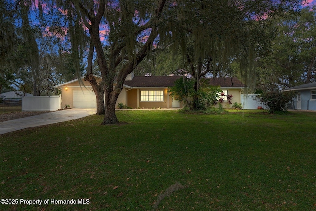 ranch-style house with a garage and a yard