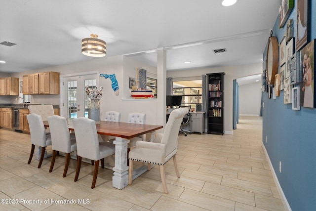 dining area with sink, a wealth of natural light, and french doors