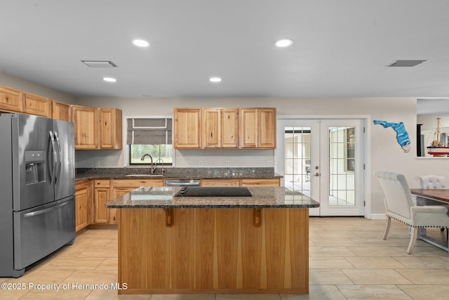 kitchen with appliances with stainless steel finishes, a center island, a kitchen breakfast bar, and french doors