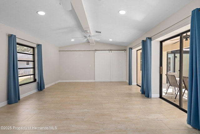 empty room featuring vaulted ceiling with beams, a barn door, and ceiling fan