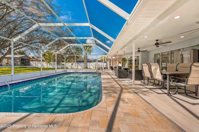 view of pool featuring a patio area, ceiling fan, and glass enclosure