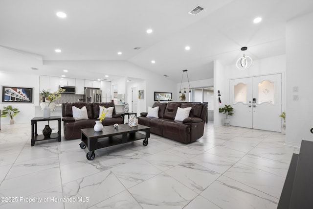 living room featuring vaulted ceiling and french doors