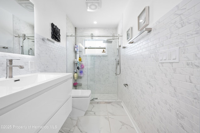bathroom with vanity, a shower with shower door, toilet, and tile walls