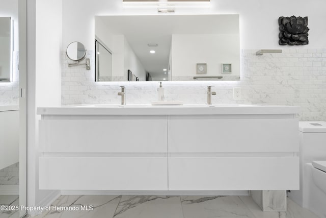 bathroom with vanity, decorative backsplash, and toilet