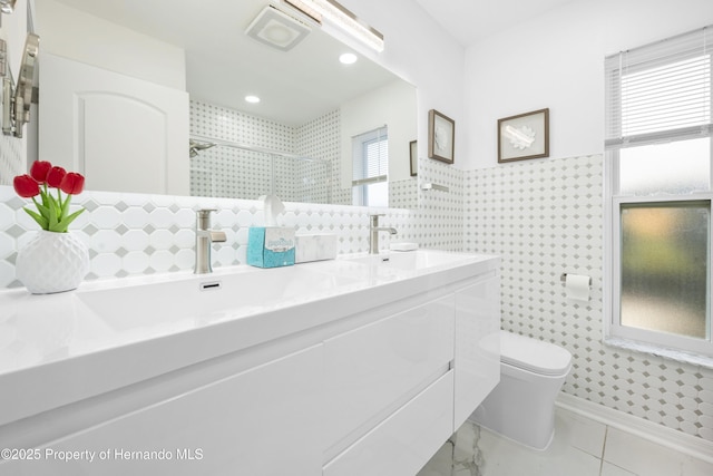 bathroom featuring an enclosed shower, vanity, tile walls, and toilet