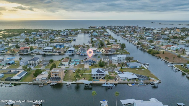 aerial view at dusk featuring a water view