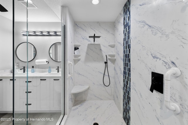 bathroom with vanity and tiled shower