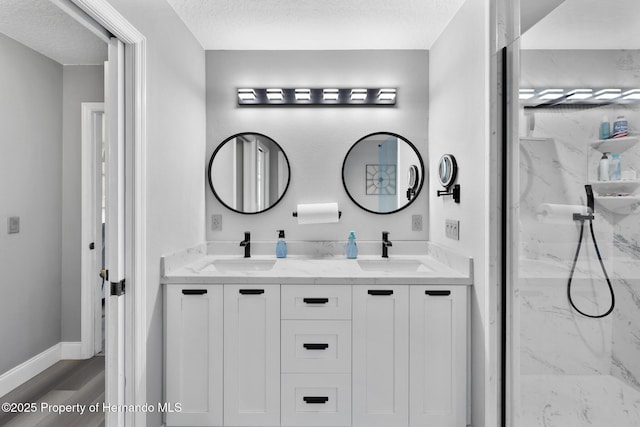 bathroom with vanity, a textured ceiling, wood-type flooring, and a shower