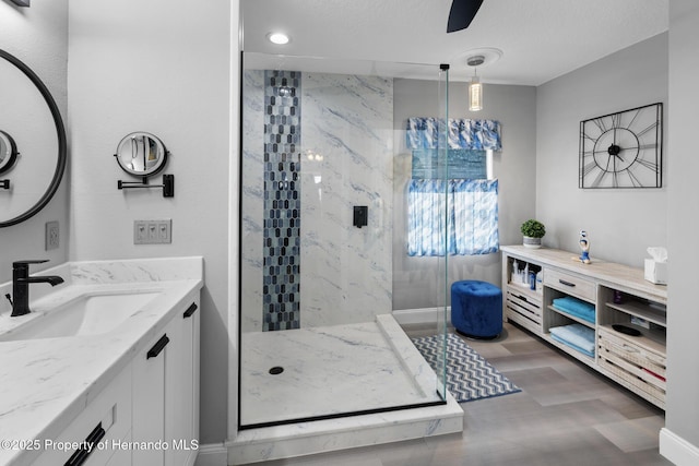 bathroom with vanity, hardwood / wood-style floors, ceiling fan, and a tile shower