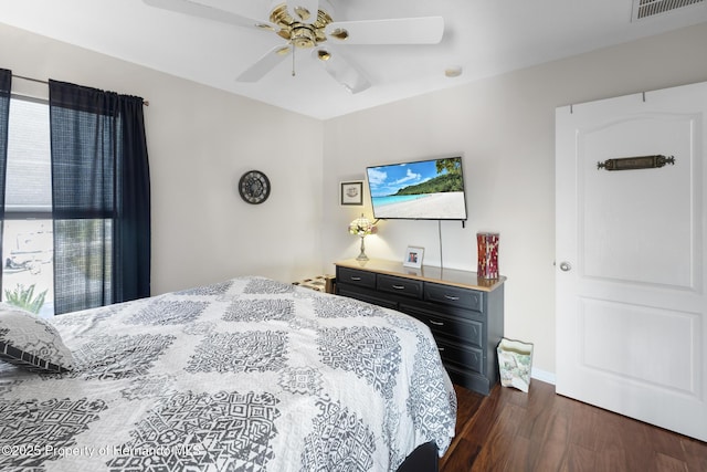 bedroom featuring multiple windows, ceiling fan, and dark hardwood / wood-style flooring