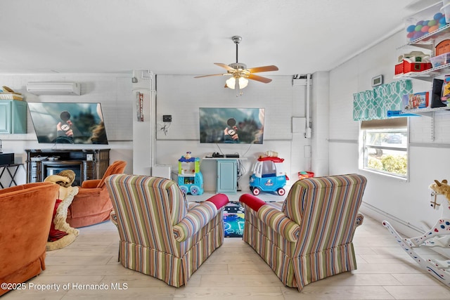 living room featuring ceiling fan, a wall mounted air conditioner, a fireplace, and light hardwood / wood-style flooring