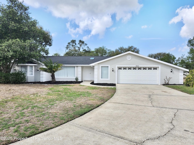 ranch-style house featuring a garage and a front lawn