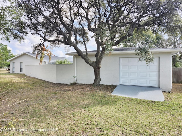 exterior space featuring a garage and a lawn