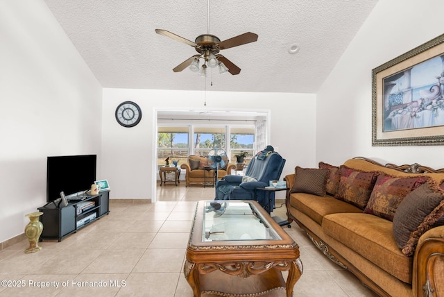 living room featuring ceiling fan, lofted ceiling, light tile patterned floors, and a textured ceiling