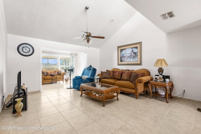 living room featuring light tile patterned floors, vaulted ceiling, and a textured ceiling