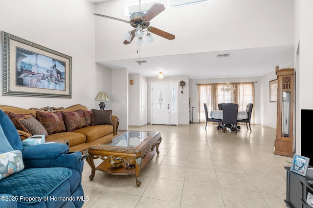 living room with ceiling fan with notable chandelier and light tile patterned floors