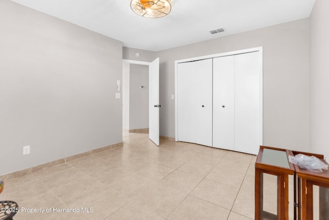 unfurnished bedroom with light tile patterned floors and a closet