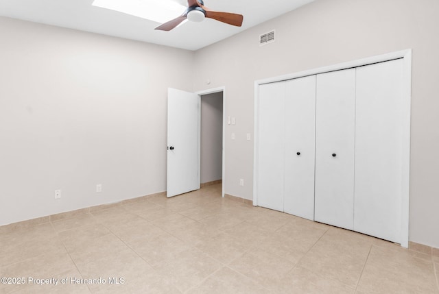 unfurnished bedroom with light tile patterned floors, a closet, and ceiling fan