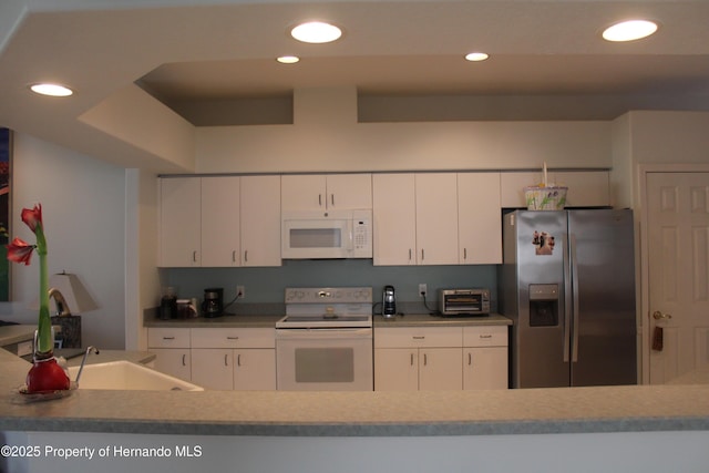 15033 Middle Fairway Dr, Spring Hill, FL 34609 - kitchen featuring white cabinetry, sink, and white appliances