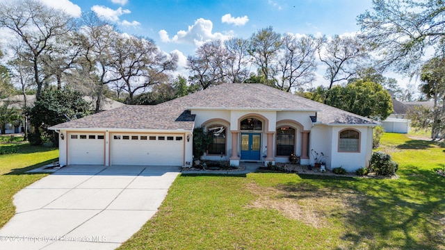 mediterranean / spanish house featuring french doors, a garage, and a front lawn