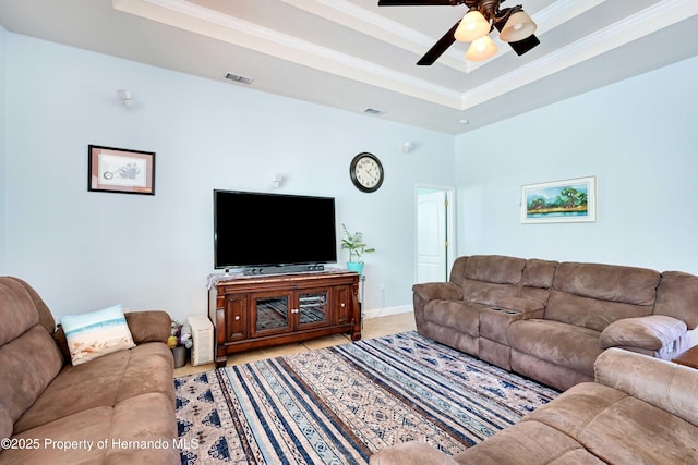 living room with crown molding, ceiling fan, and a raised ceiling