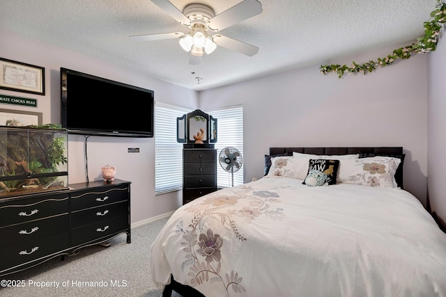 carpeted bedroom with ceiling fan and a textured ceiling