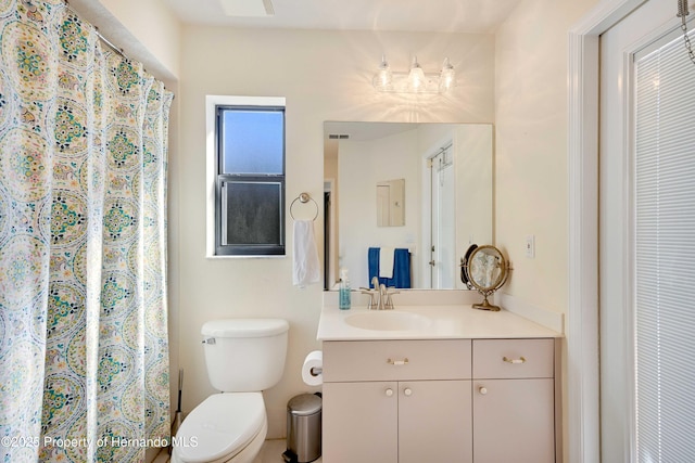 bathroom featuring vanity, walk in shower, and toilet