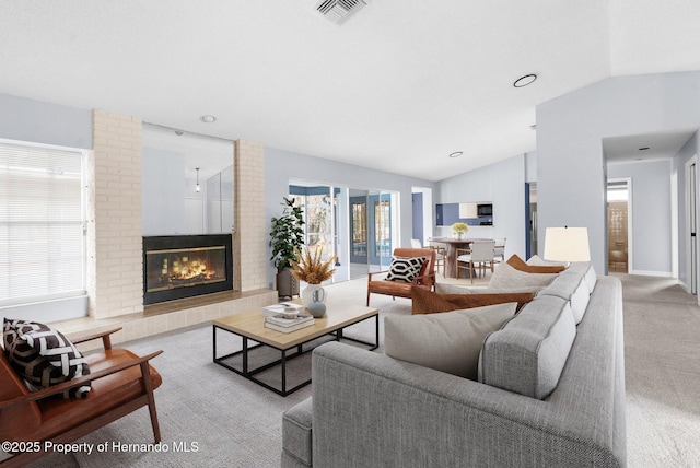 carpeted living room featuring vaulted ceiling and a brick fireplace