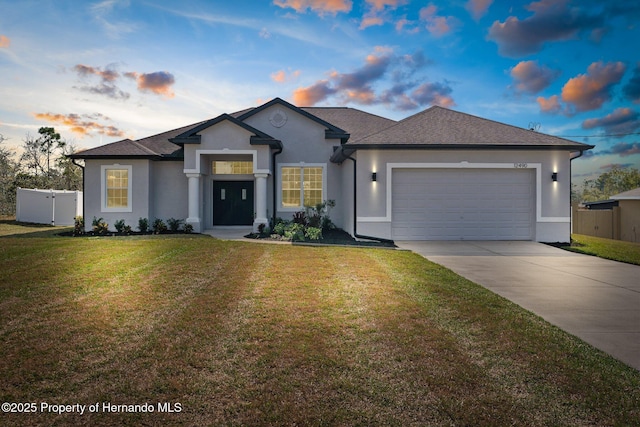 view of front of home with a garage and a lawn