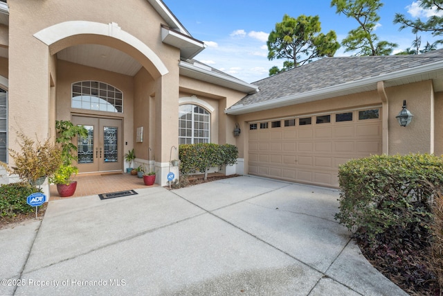 doorway to property with a garage and french doors