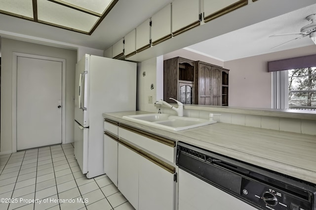 kitchen with sink, light tile patterned floors, dishwasher, white fridge, and white cabinets