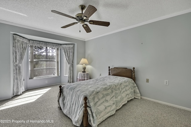 carpeted bedroom featuring ceiling fan, ornamental molding, and a textured ceiling