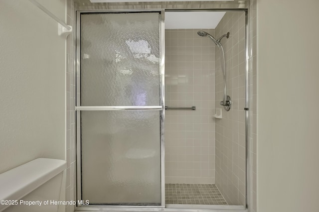 bathroom with an enclosed shower and toilet