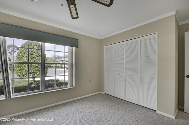 unfurnished bedroom with crown molding, a closet, and ceiling fan