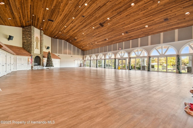 unfurnished living room featuring high vaulted ceiling, light hardwood / wood-style flooring, and wooden ceiling