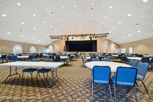 dining area with track lighting, high vaulted ceiling, and carpet