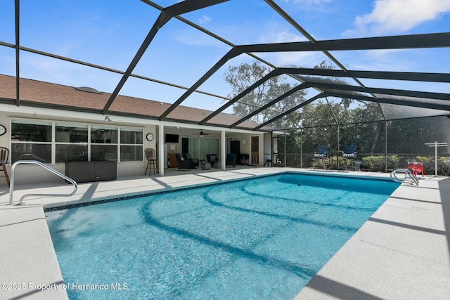 view of swimming pool featuring a lanai, a patio area, and ceiling fan