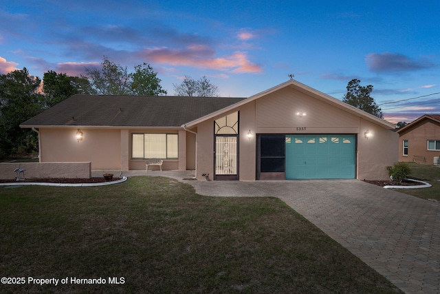 view of front of property with a garage and a lawn